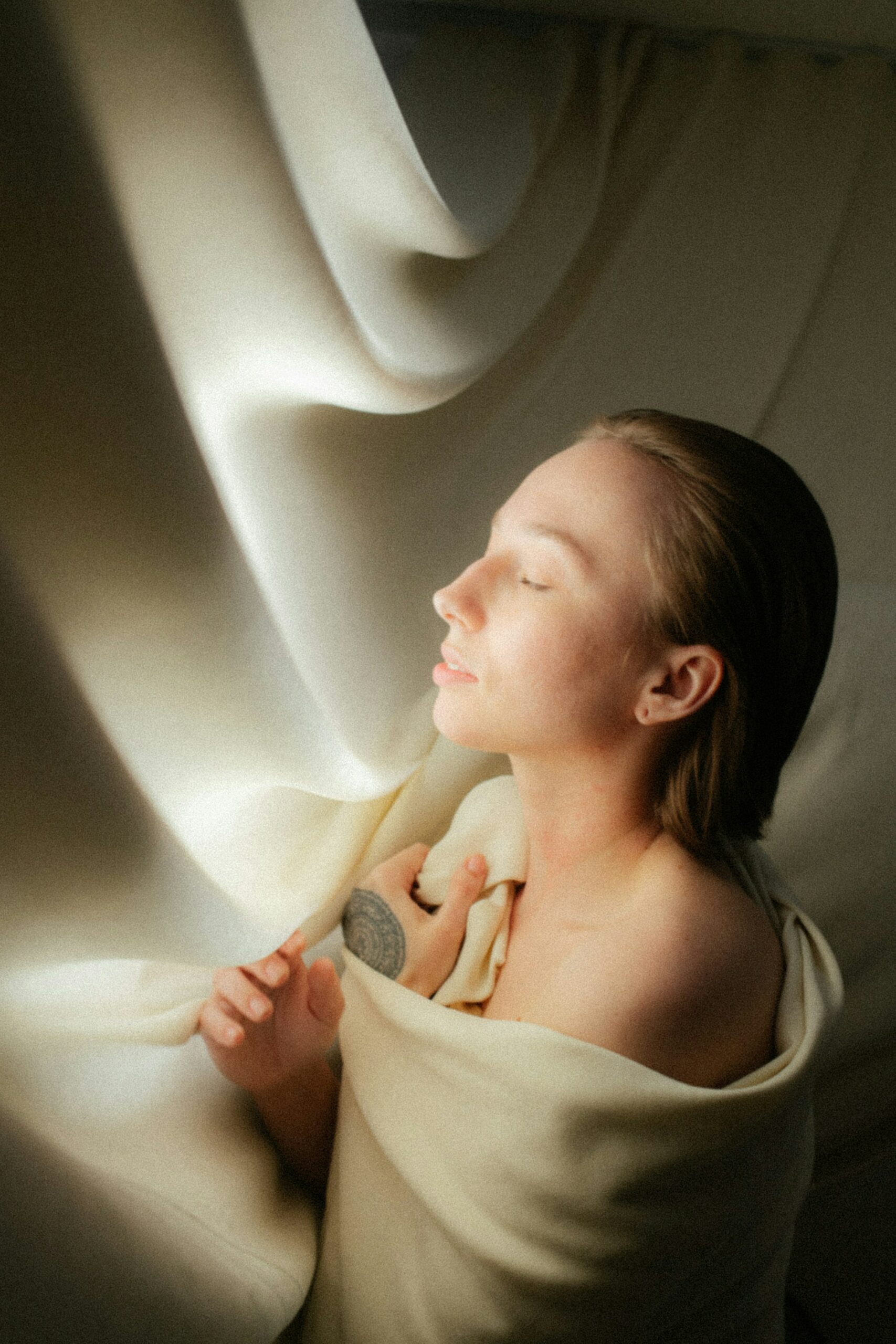 Une femme apaisée, enveloppée de lumière dans une ambiance relaxante.